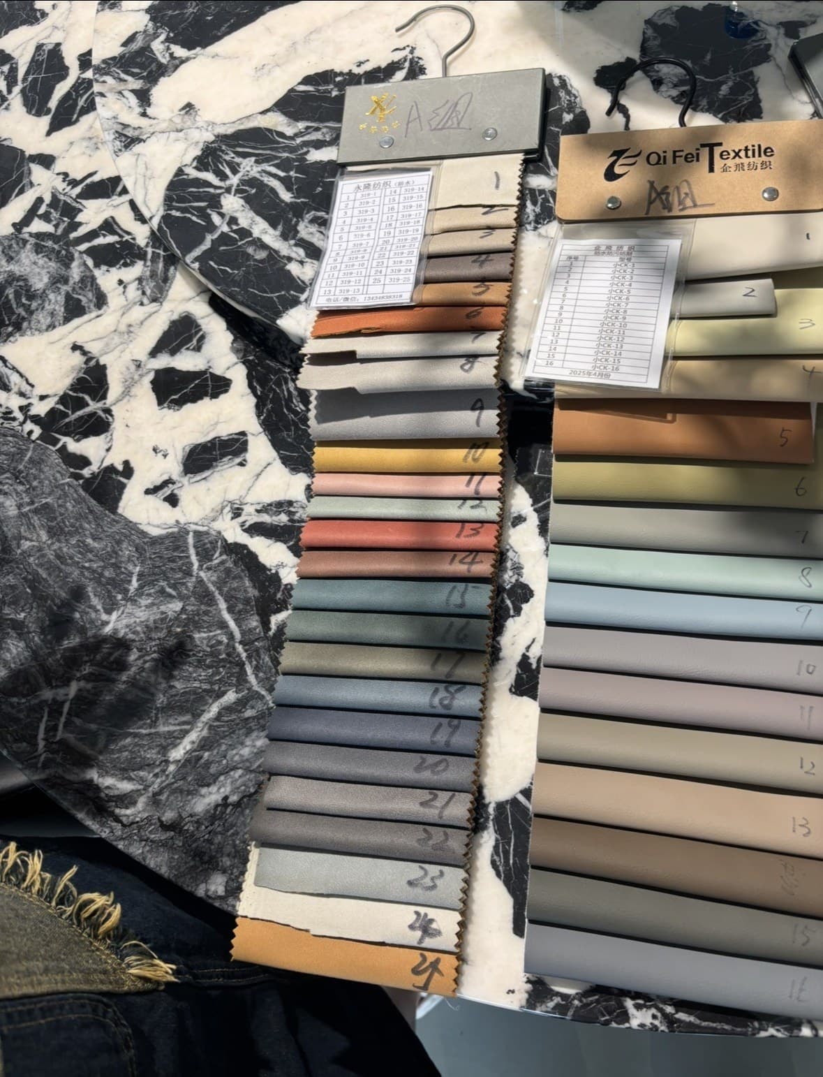 Fabric swatch books from textile suppliers, photographed on the team's factory trip in China