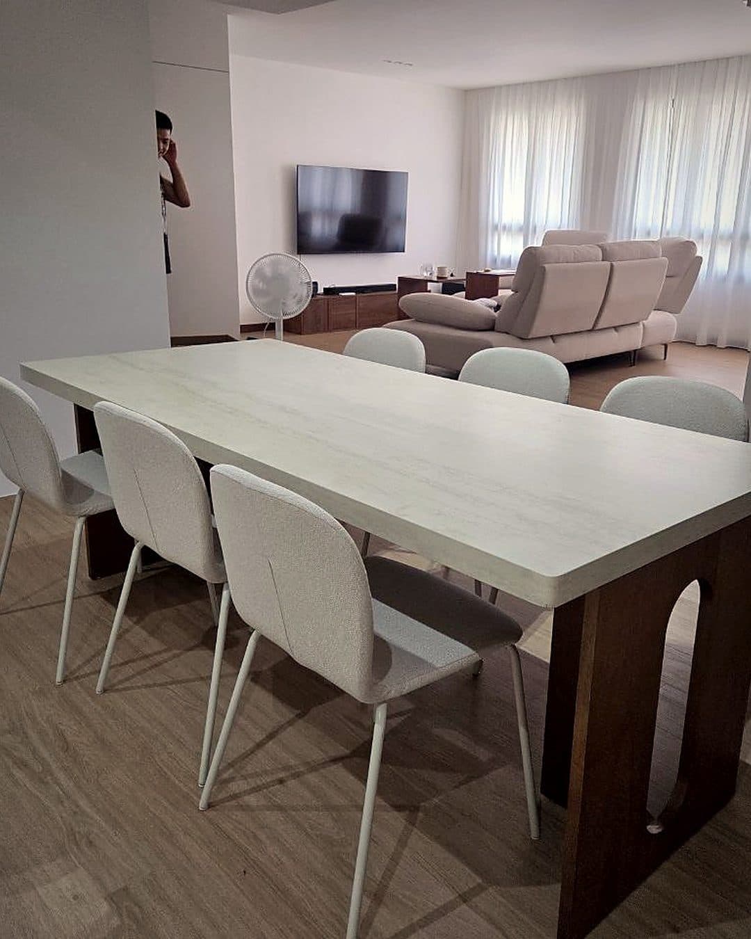 A pale dining table and white chairs in a BTO flat, with room behind each chair