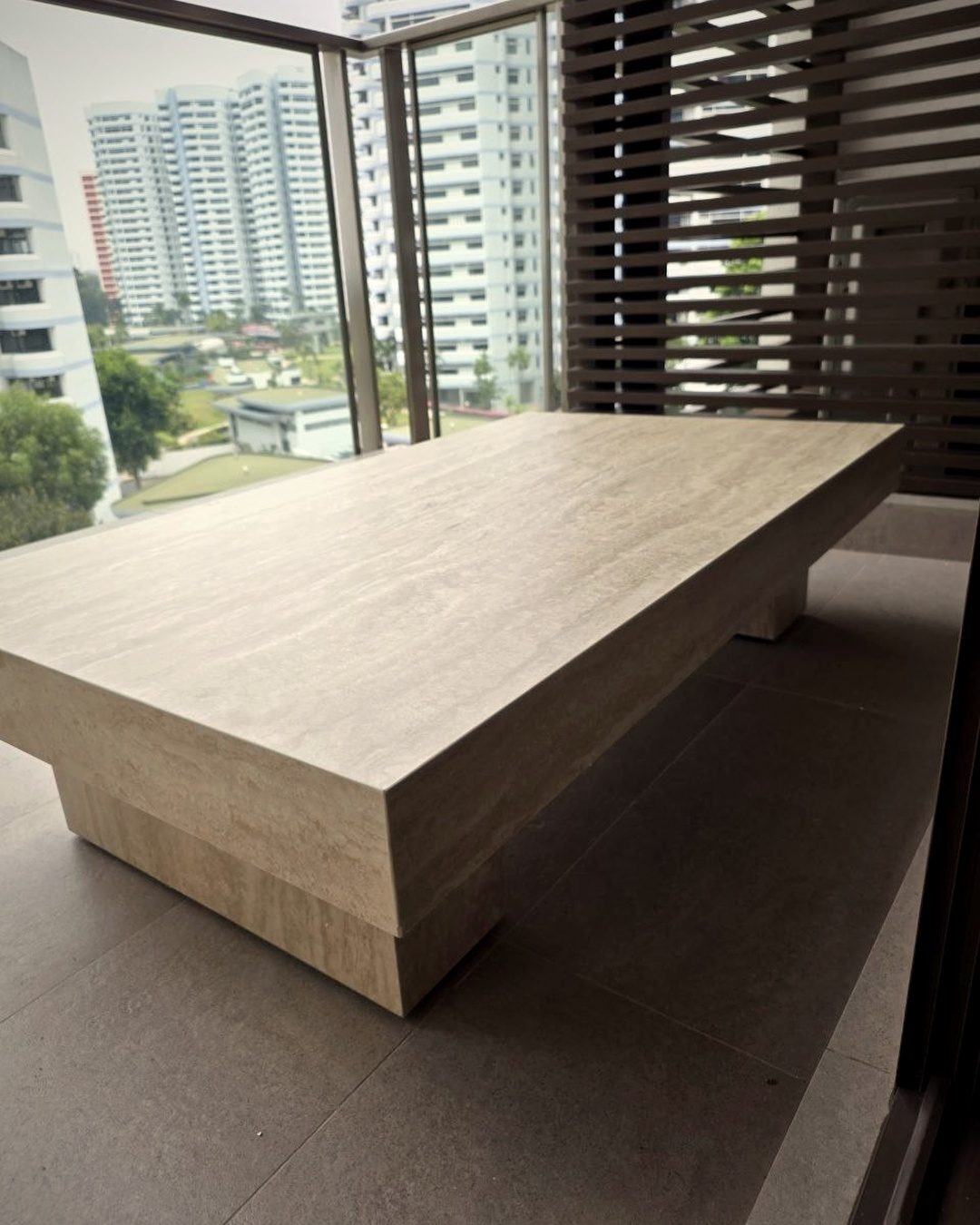 A near-empty new flat with one travertine coffee table and a large bare floor