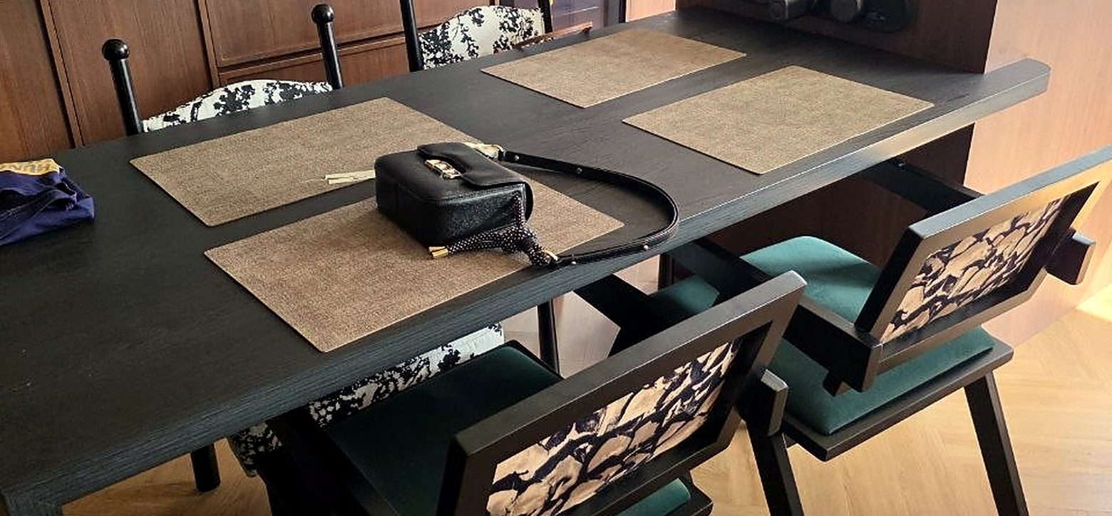 A finished BTO dining area with a dark dining table, patterned chairs and warm lighting