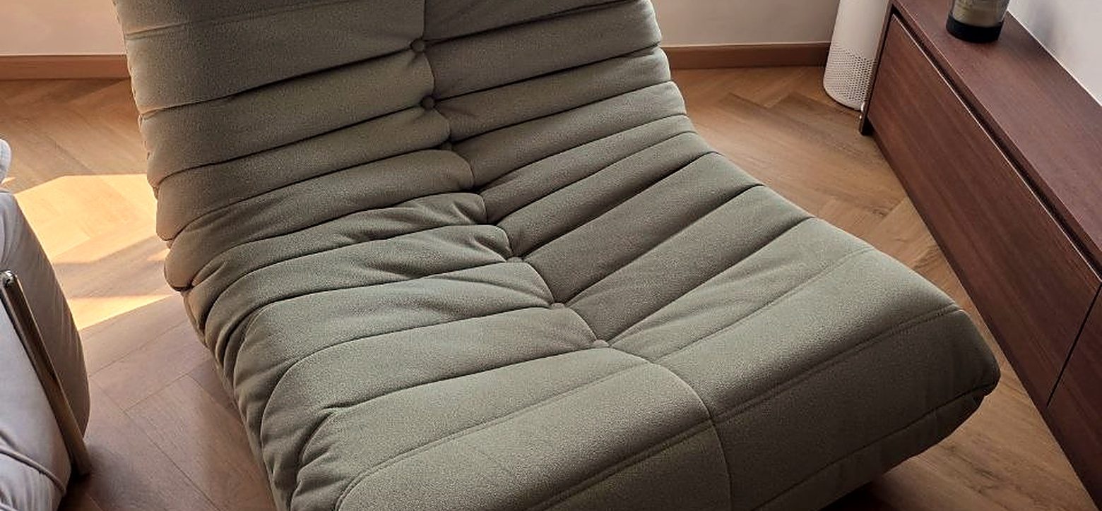 A green lounge chair in a finished Singapore home with timber floors