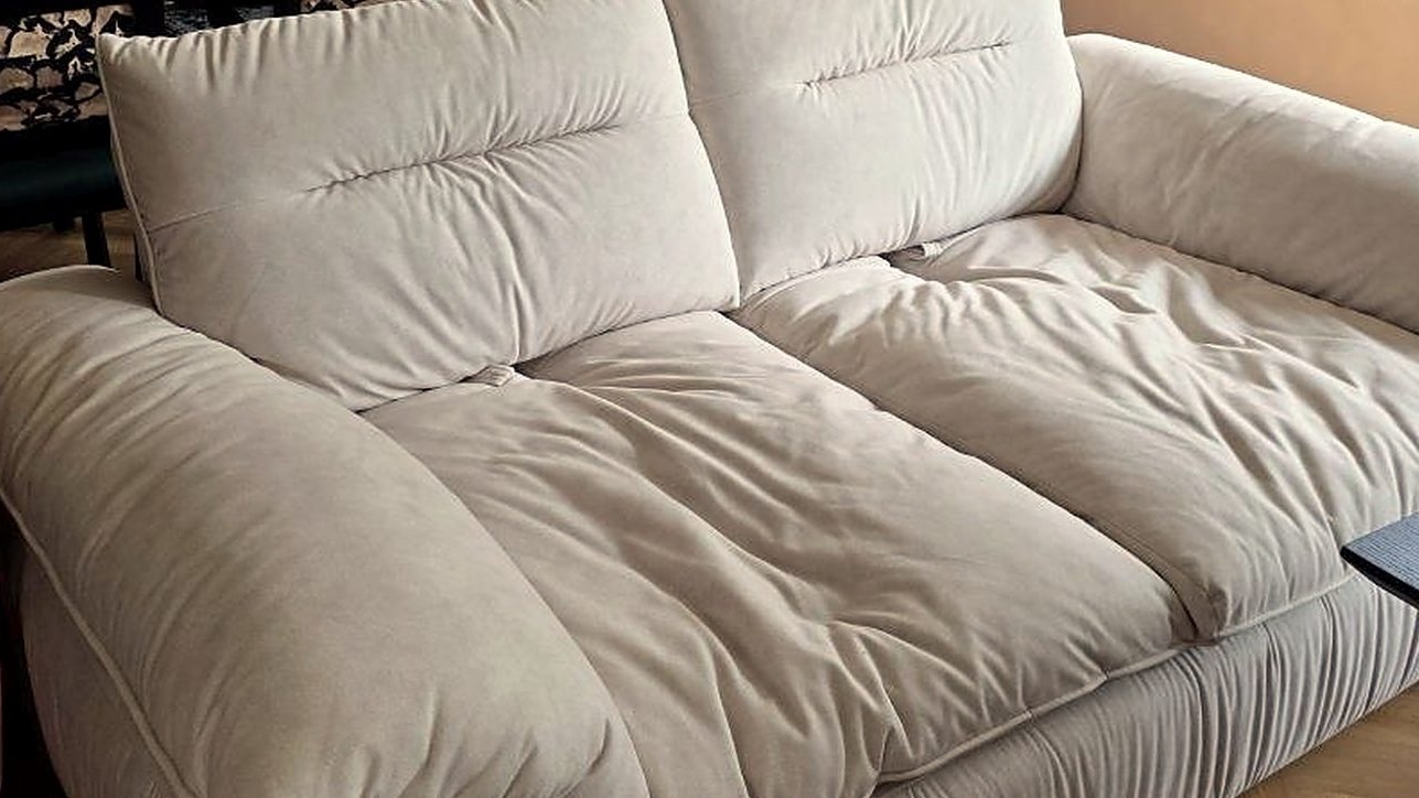 Close-up of a plush cream sofa with deep feather-soft seat cushions